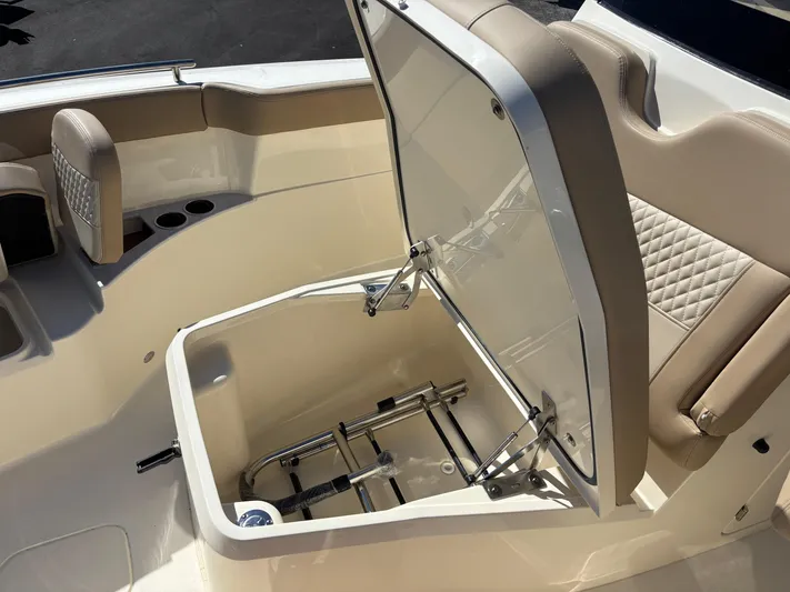 Yacht Photos Pics 2025 Scout 260 LXF boat with open storage compartment and beige seating.