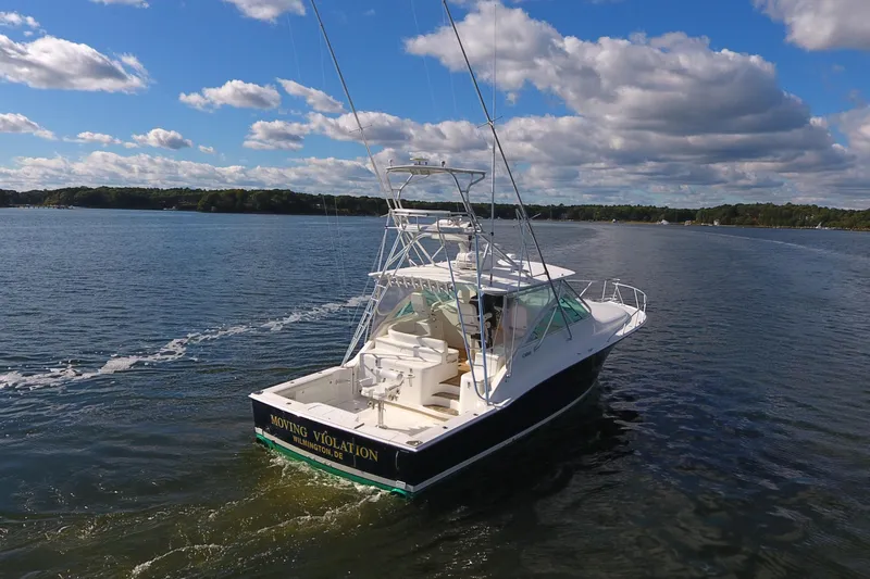 Moving Violation Yacht Photos Pics 2008 Cabo 40 boat cruising on a sunny day with blue skies and clouds.