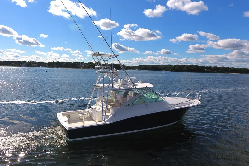 Moving Violation Yacht Photos Pics 2008 Cabo 40 boat cruising on a sunny day with blue skies and clouds.