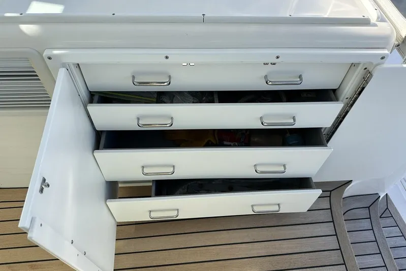 Moving Violation Yacht Photos Pics Open storage drawers on a 2008 Cabo 40 boat with wooden flooring.