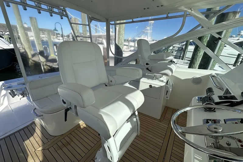 Moving Violation Yacht Photos Pics Luxurious 2008 Cabo 40 yacht helm with white leather seats and wooden deck.