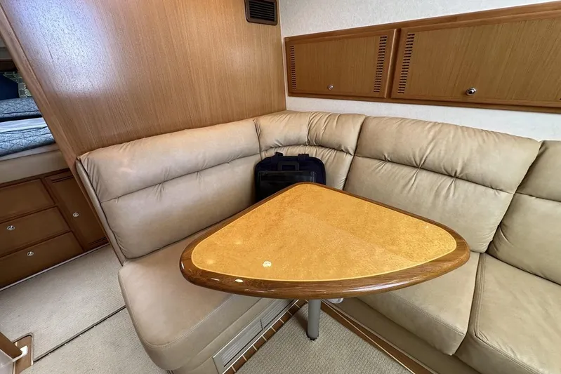 Moving Violation Yacht Photos Pics Luxurious interior of a 2008 Cabo 40 yacht with beige seating and wooden table.