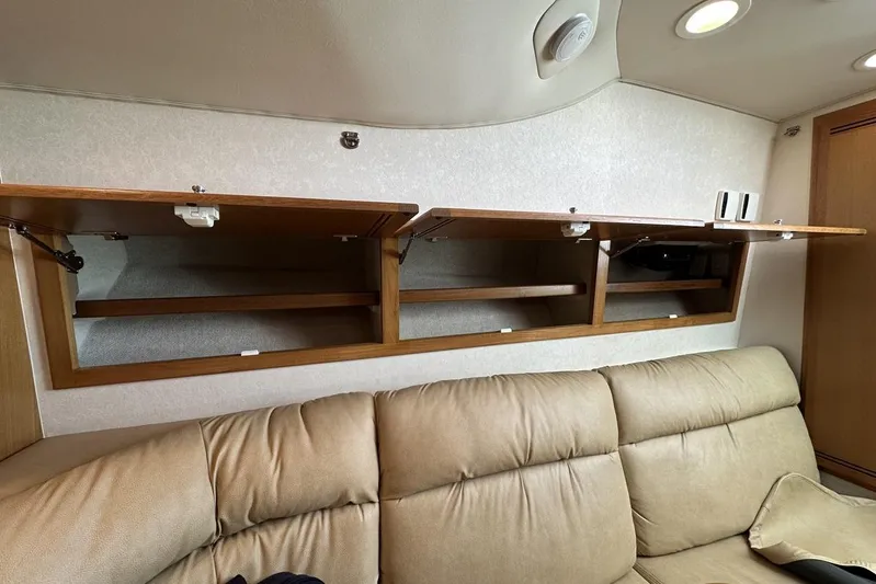 Moving Violation Yacht Photos Pics Open wooden cabinets above beige sofa in 2008 Cabo 40 interior.