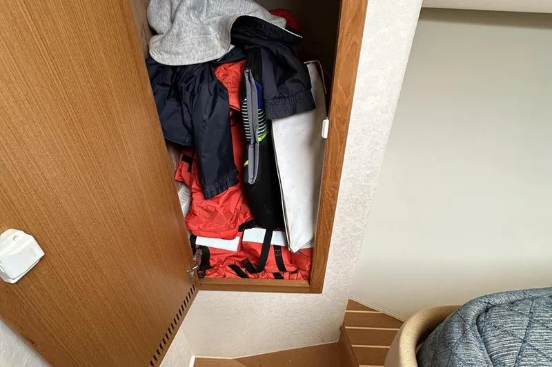 Moving Violation Yacht Photos Pics Storage compartment in a 2008 Cabo 40 boat, filled with jackets and gear.