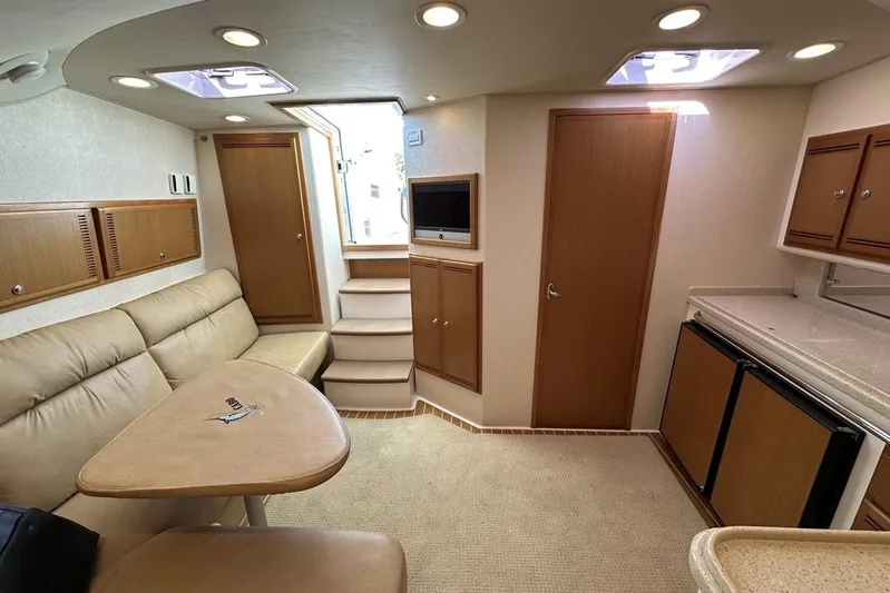 Moving Violation Yacht Photos Pics Luxurious 2008 Cabo 40 yacht interior with beige seating, kitchenette, and stairs.