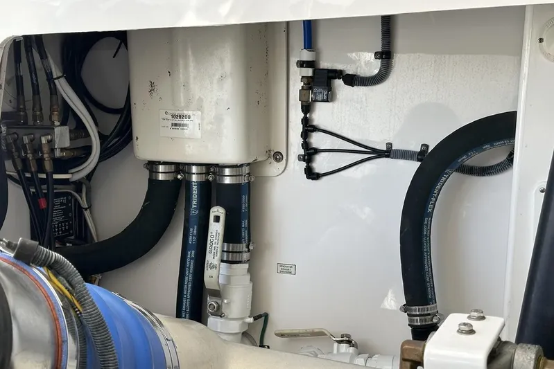 Moving Violation Yacht Photos Pics Engine compartment of a 2008 Cabo 40 boat, featuring hoses and mechanical components.