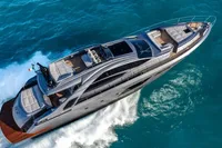Luxury 2020 Pershing 8X yacht cruising on turquoise waters, aerial view.