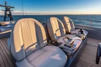 Luxurious seating on 2020 Pershing 8X yacht with ocean view at sunset.