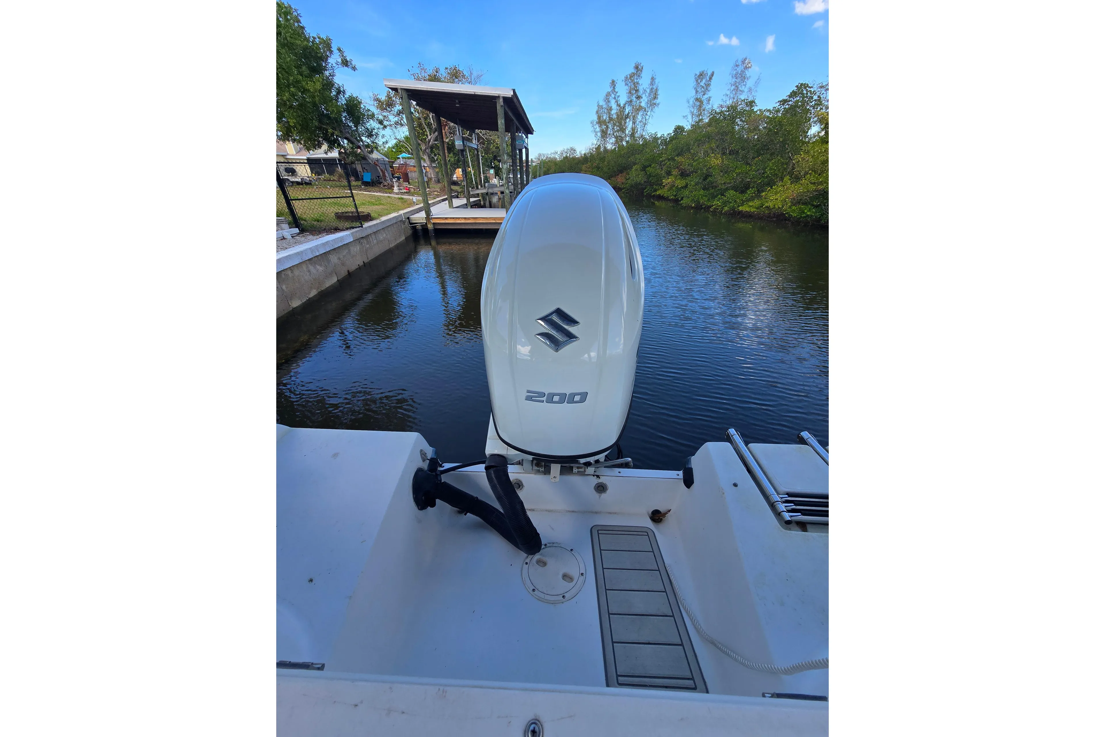 2004 Seaswirl Striper 2101 Walkaround O/B with Suzuki outboard engine by a dock.