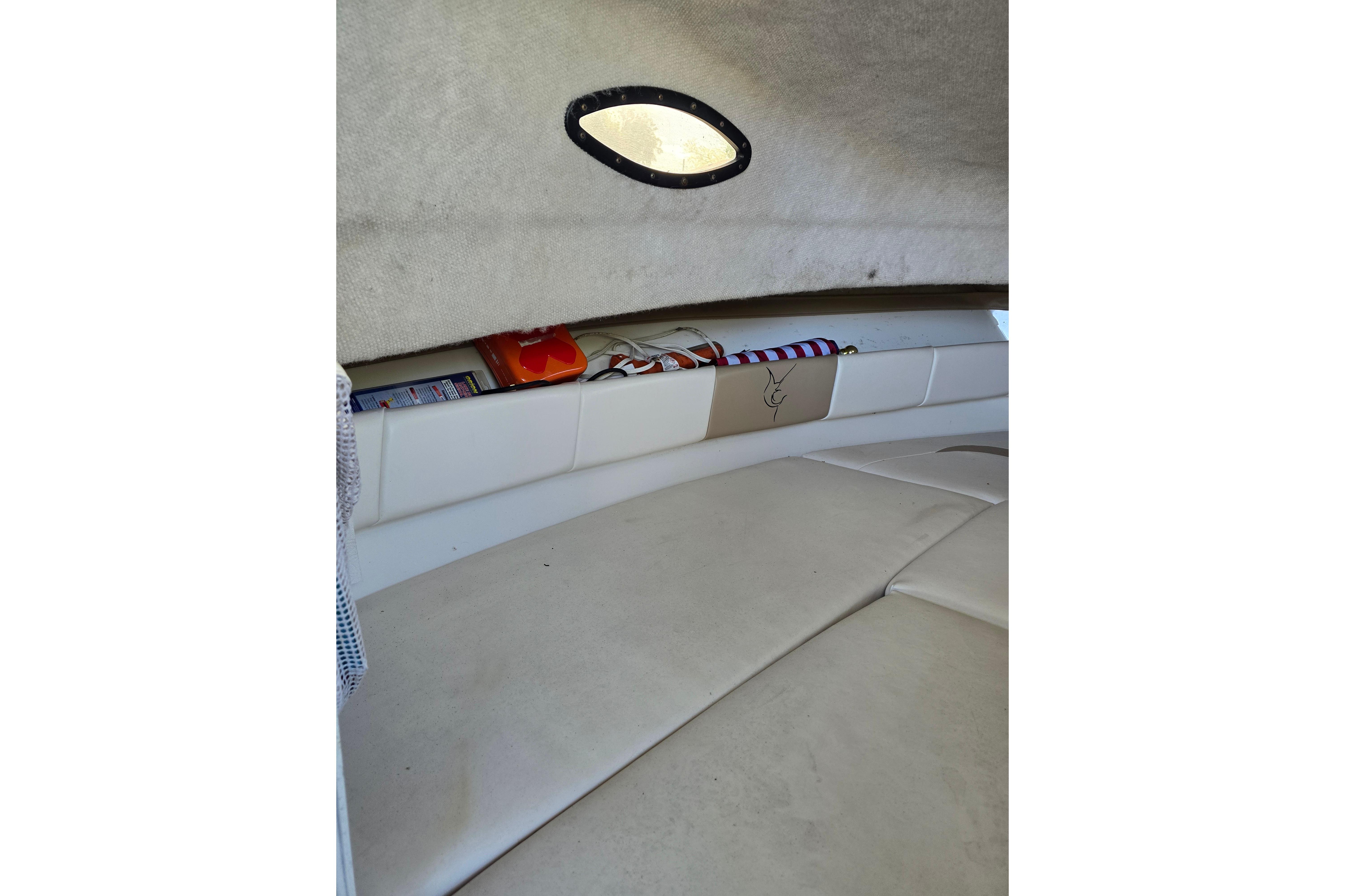 2004 Seaswirl Striper 2101 Walkaround O/B cabin interior with storage and seating.