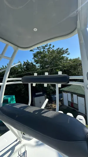 Yacht Photos Pics Boston Whaler 350 Outrage 2014 boat with seating and rod holders, surrounded by trees.