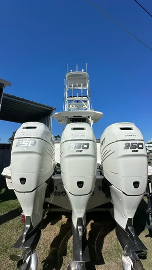  Yacht Photos Pics 2014 Boston Whaler 350 Outrage with triple 350 engines, viewed from the rear under clear blue sky.