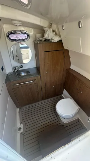  Yacht Photos Pics 2014 Boston Whaler 350 Outrage boat bathroom with wood cabinetry and compact design.