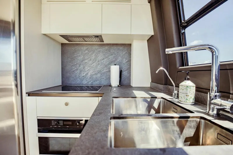 Transcendence Yacht Photos Pics Modern kitchen interior on 2020 Azimut 78 Flybridge yacht, featuring sleek countertops and dual sinks.