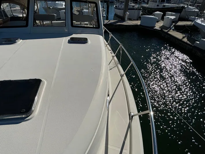 Bay Cruzin Yacht Photos Pics 2004 Mainship Pilot 34 Rum Runner II Hardtop docked, sunlit water reflecting nearby.
