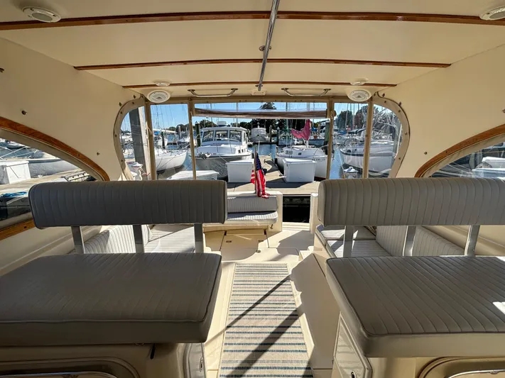 Bay Cruzin Yacht Photos Pics Interior view of 2004 Mainship Pilot 34 Rum Runner II Hardtop, featuring seating and marina backdrop.