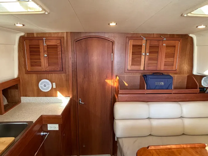 Bay Cruzin Yacht Photos Pics 2004 Mainship Pilot 34 Rum Runner II interior with wood cabinetry and cream seating.
