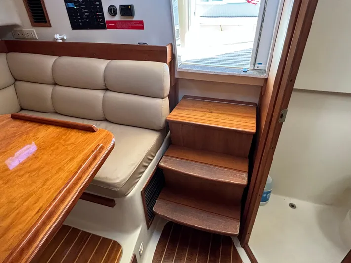 Bay Cruzin Yacht Photos Pics 2004 Mainship Pilot 34 Rum Runner II interior with wooden steps and cushioned seating.
