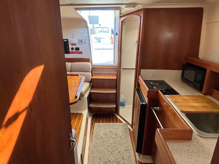 Bay Cruzin Yacht Photos Pics Interior of 2004 Mainship Pilot 34 Rum Runner II, featuring kitchen and seating area.