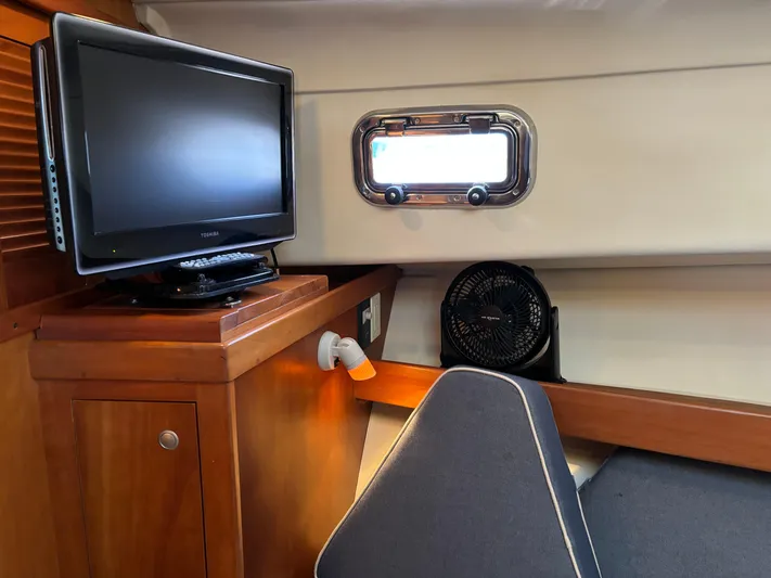 Bay Cruzin Yacht Photos Pics 2004 Mainship Pilot 34 Rum Runner II cabin interior with TV and porthole.