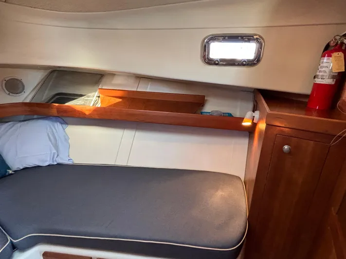 Bay Cruzin Yacht Photos Pics 2004 Mainship Pilot 34 Rum Runner II cabin interior with bed, window, and fire extinguisher.