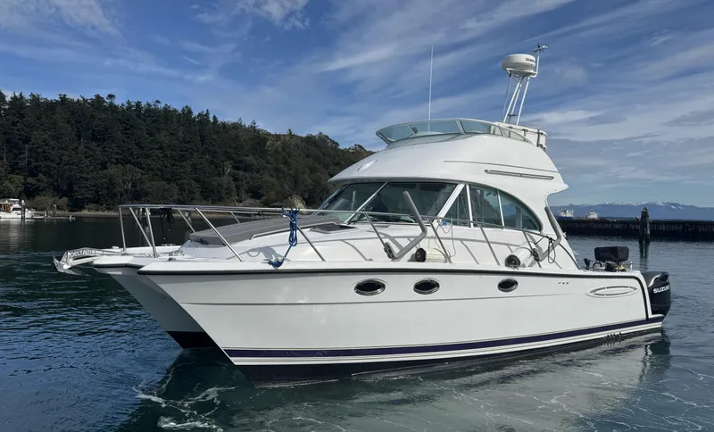 Ocelot Yacht Photos Pics 2005 Glacier Bay 3490 Ocean Runner boat on calm water, with forested shoreline background.