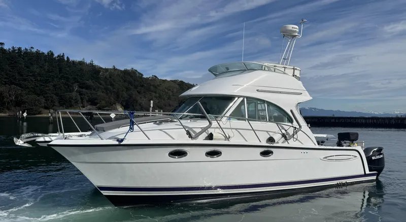 Ocelot Yacht Photos Pics 2005 Glacier Bay 3490 Ocean Runner boat on calm water, with forested shoreline in background.