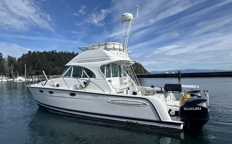 Ocelot Yacht Photos Pics 2005 Glacier Bay 3490 Ocean Runner boat on calm water, featuring Suzuki outboard motor.