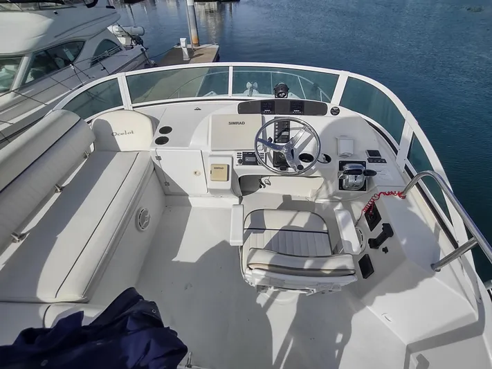 Ocelot Yacht Photos Pics 2005 Glacier Bay 3490 Ocean Runner boat helm with seating, docked on calm water.