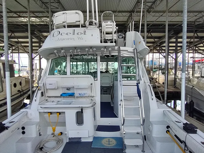 Ocelot Yacht Photos Pics 2005 Glacier Bay 3490 Ocean Runner boat docked in a marina, rear view.