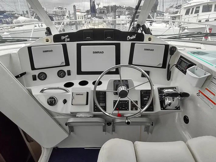 Ocelot Yacht Photos Pics Helm of 2005 Glacier Bay 3490 Ocean Runner with Simrad navigation systems and steering wheel.