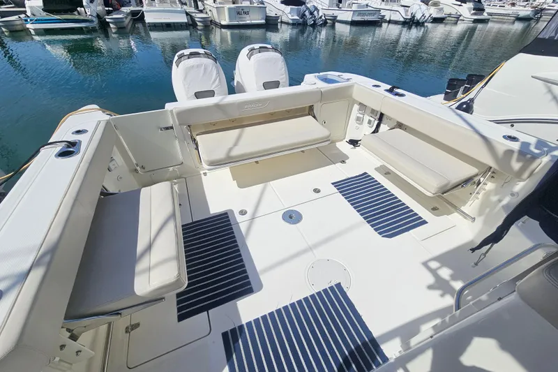 Day For It Yacht Photos Pics 2018 Boston Whaler 315 Conquest boat interior with seating and striped mats at marina.