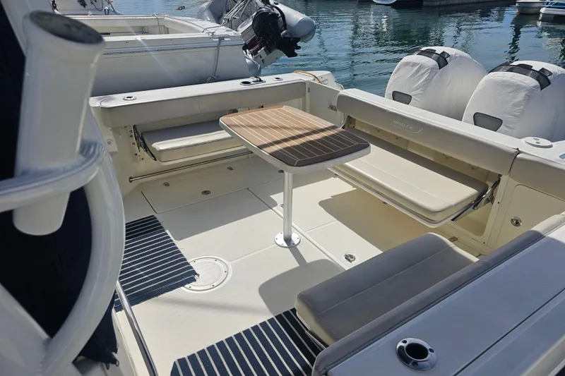 Day For It Yacht Photos Pics 2018 Boston Whaler 315 Conquest boat interior with seating and table, docked at marina.
