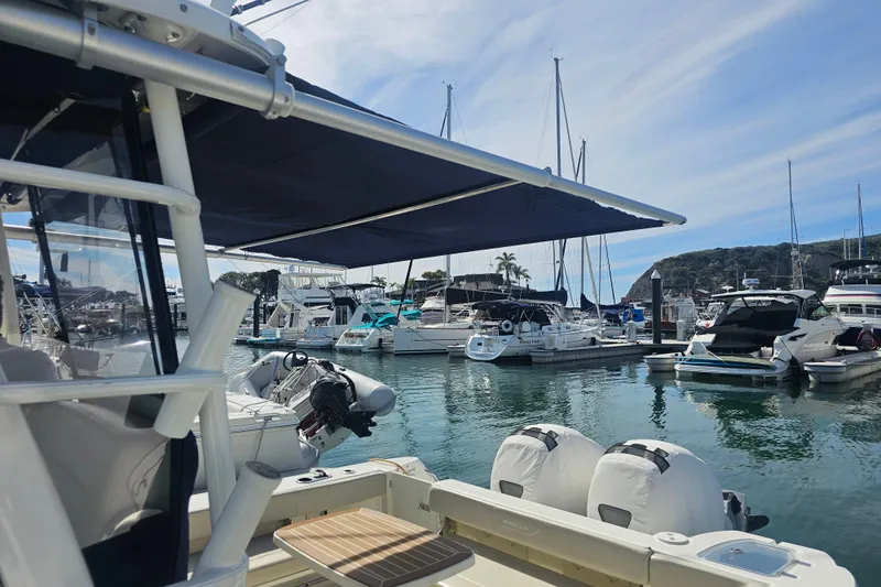 Day For It Yacht Photos Pics 2018 Boston Whaler 315 Conquest docked in a marina, surrounded by various boats.