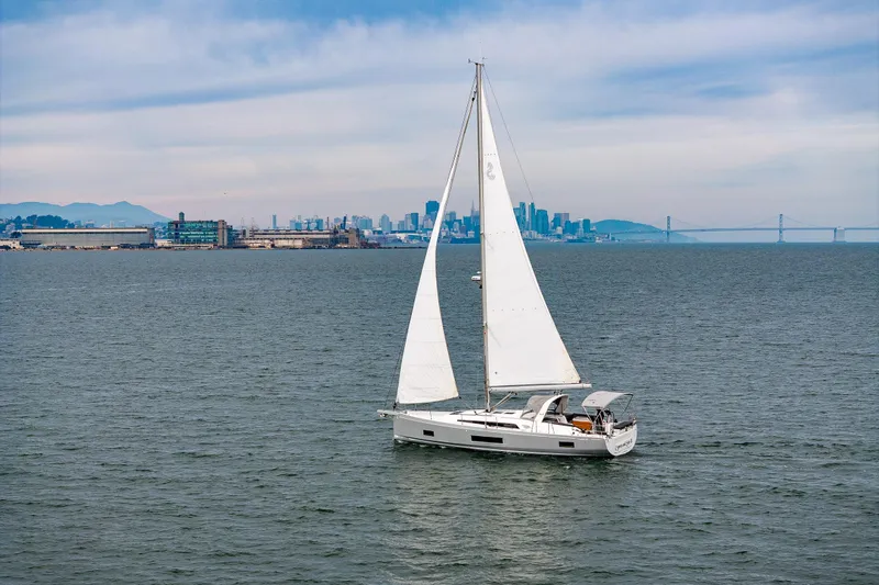 Cypress And Star II Yacht Photos Pics 2020 Beneteau Oceanis 46.1 sailing near city skyline and bridge on a clear day.