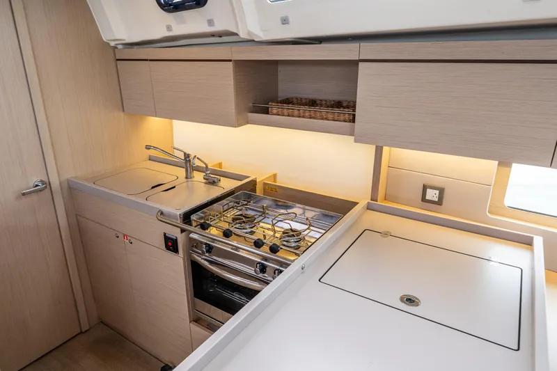 Cypress And Star II Yacht Photos Pics Modern kitchen in 2020 Beneteau Oceanis 46.1 yacht with stove, sink, and storage cabinets.