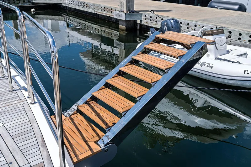 Don Tortuga Yacht Photos Pics Luxury yacht Sunseeker 90 Ocean 2024 with elegant wooden boarding stairs at marina.
