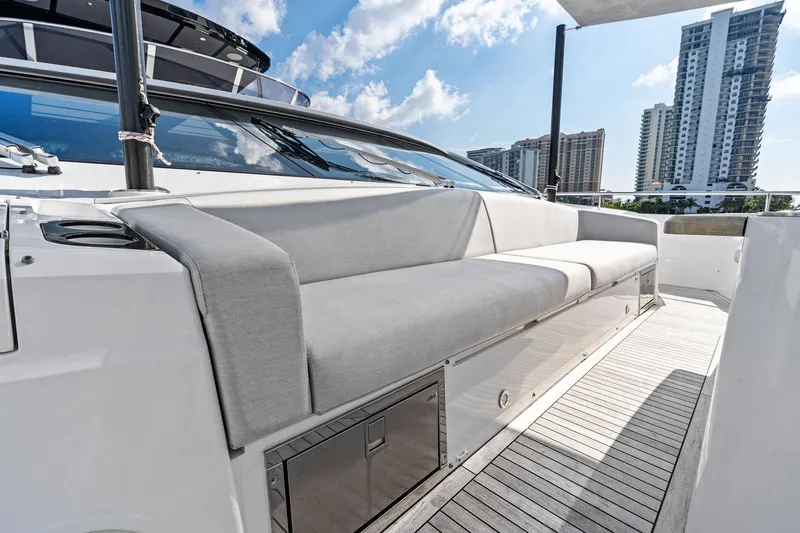 Don Tortuga Yacht Photos Pics 2024 Sunseeker 90 Ocean yacht deck with modern seating and cityscape view.
