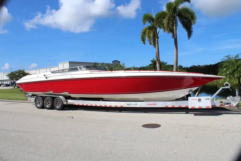 Lightning Yacht Photos Pics Red 2007 Fountain 42 Lightning boat on trailer, parked near palm trees.