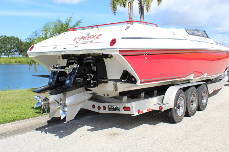 Lightning Yacht Photos Pics 2007 Fountain 42 Lightning speedboat on trailer, red and white design, parked near a lake.