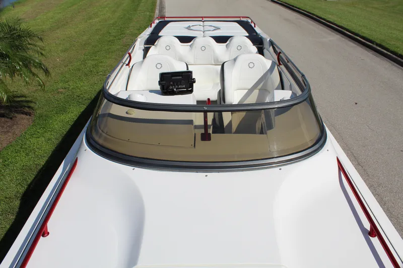 Lightning Yacht Photos Pics 2007 Fountain 42 Lightning speedboat with white seats and red accents, parked on grass.