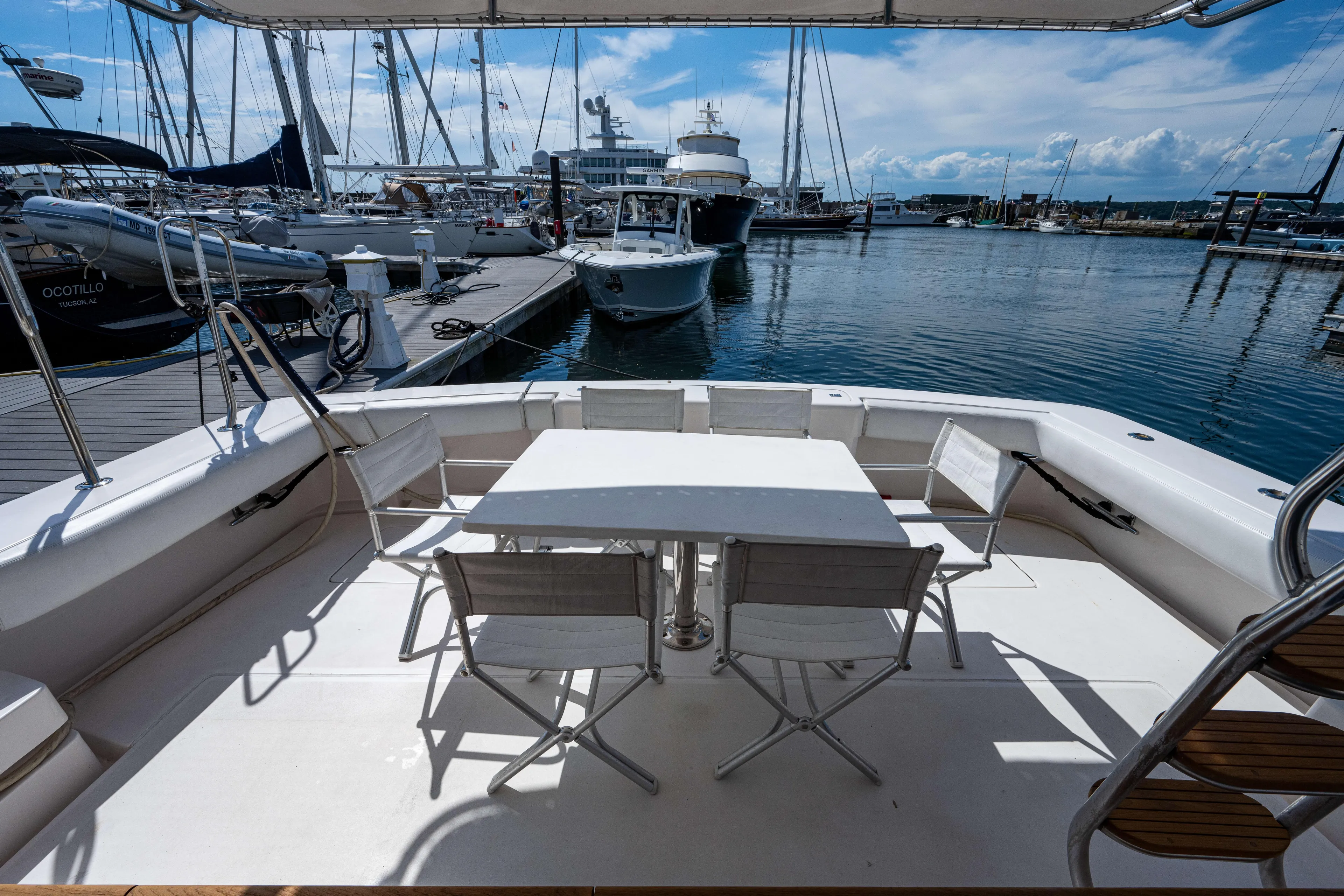 Nine Yacht Photos Pics Bertram 570 yacht deck with seating area, docked at marina, 2008 model.