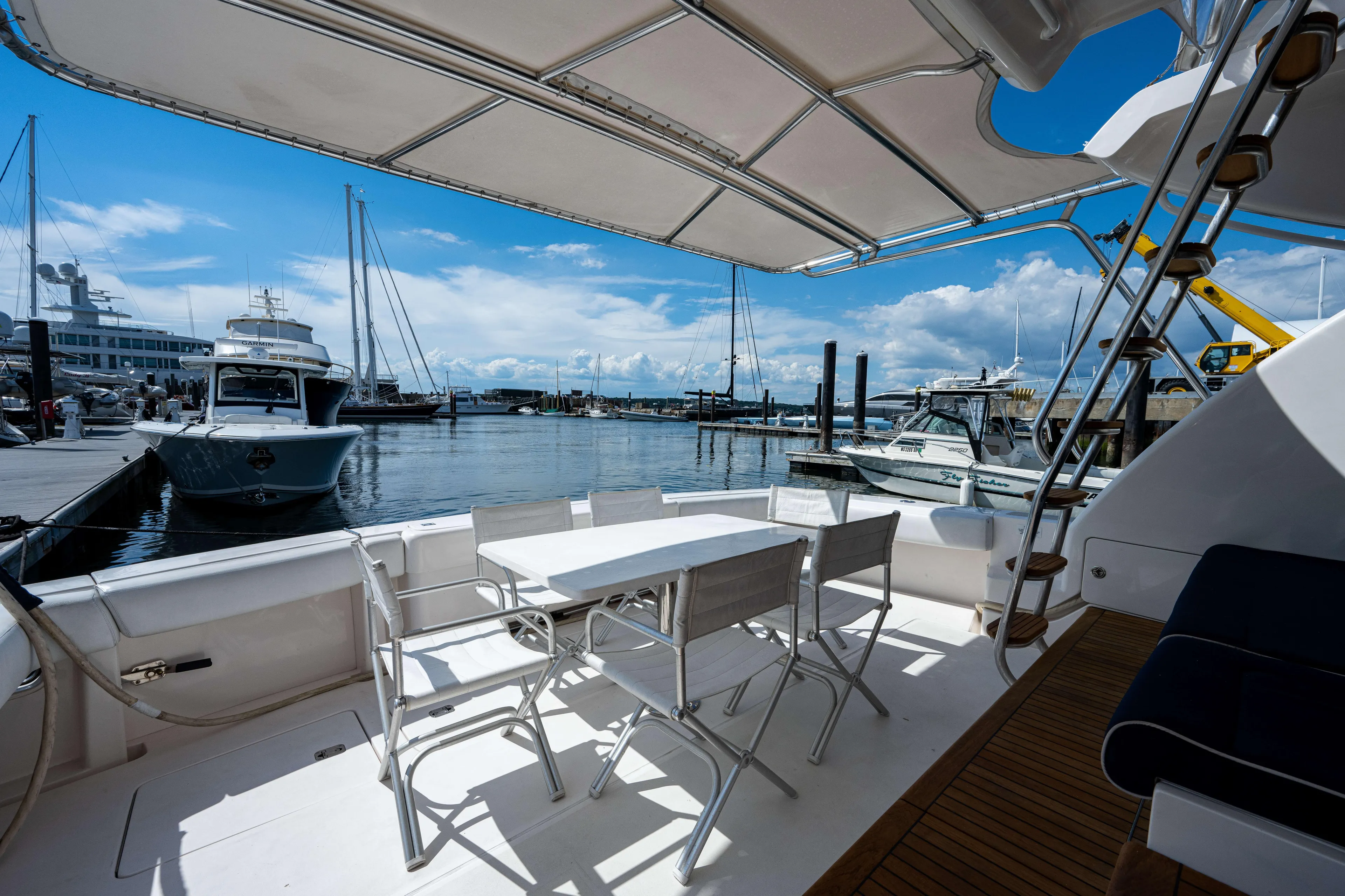 Nine Yacht Photos Pics Luxury yacht Bertram 570 (2008) docked at marina, featuring outdoor seating and scenic views.