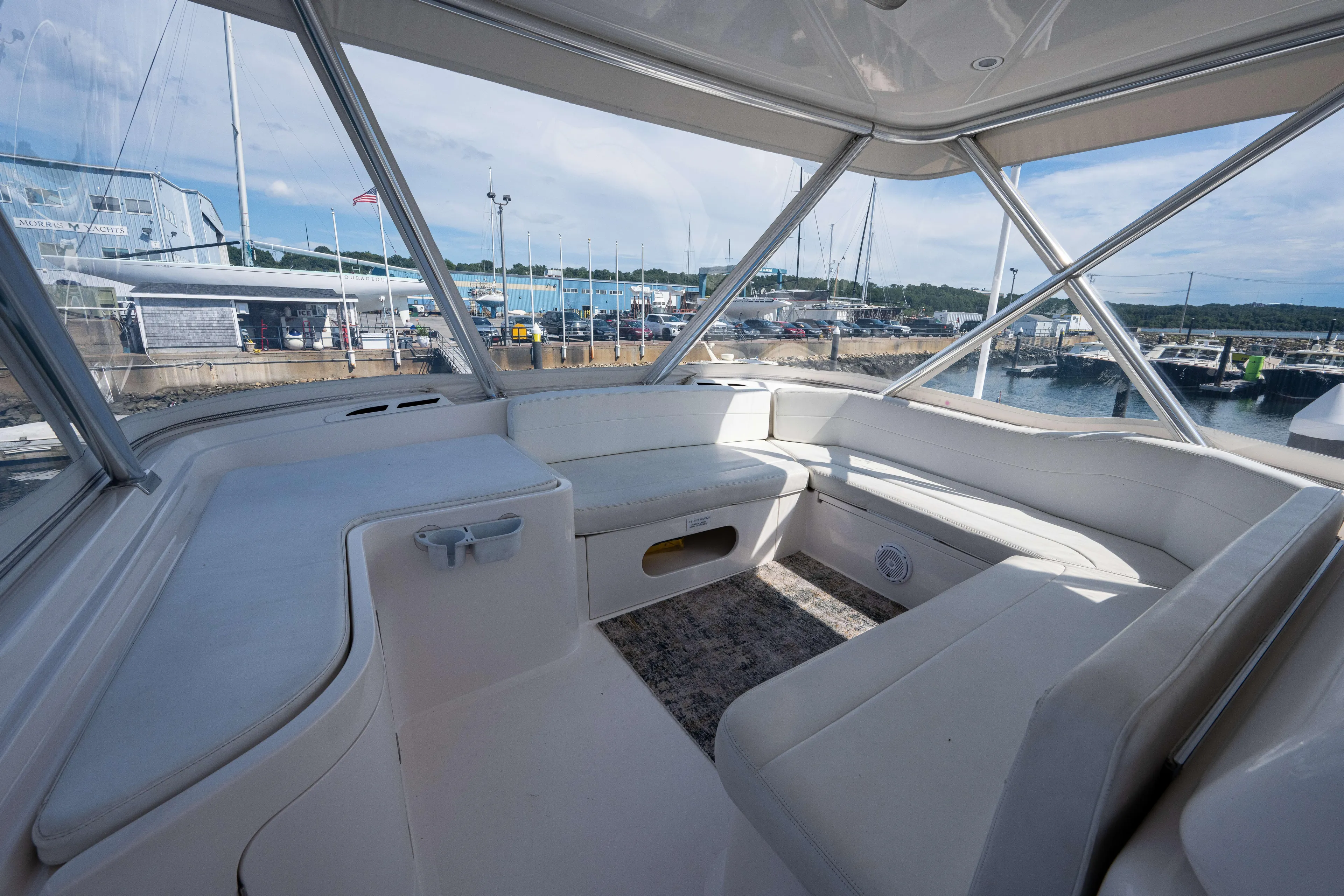 Nine Yacht Photos Pics Interior view of a 2008 Bertram 570 yacht with white seating and marina backdrop.