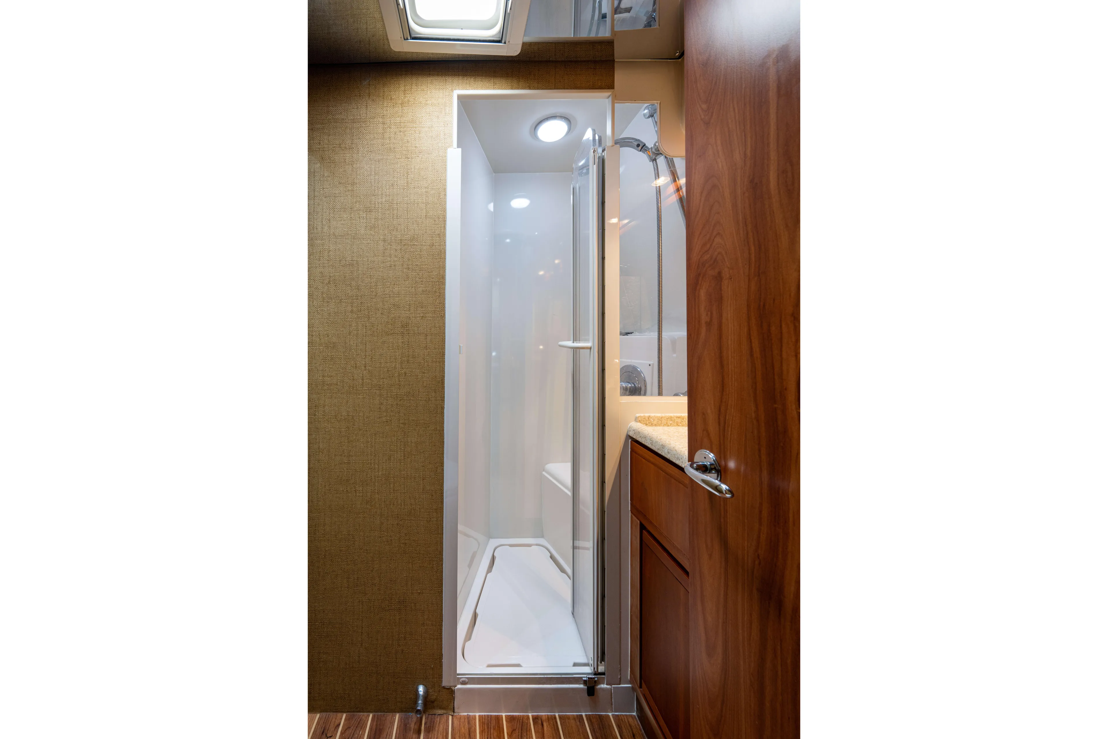 Nine Yacht Photos Pics 2008 Bertram 570 yacht bathroom with shower, wooden cabinetry, and modern fixtures.