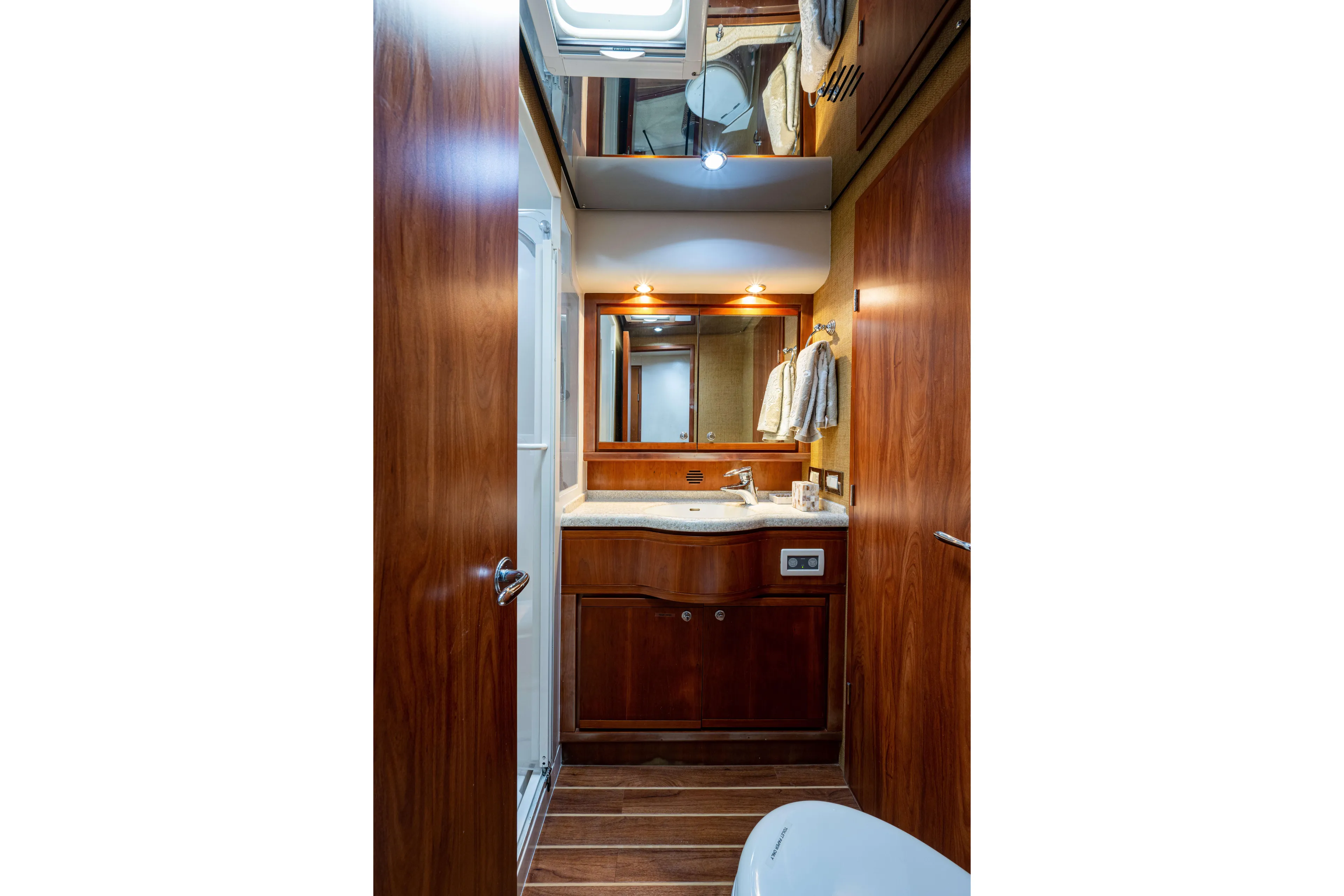 Nine Yacht Photos Pics Luxurious 2008 Bertram 570 yacht bathroom with wooden cabinetry and modern fixtures.