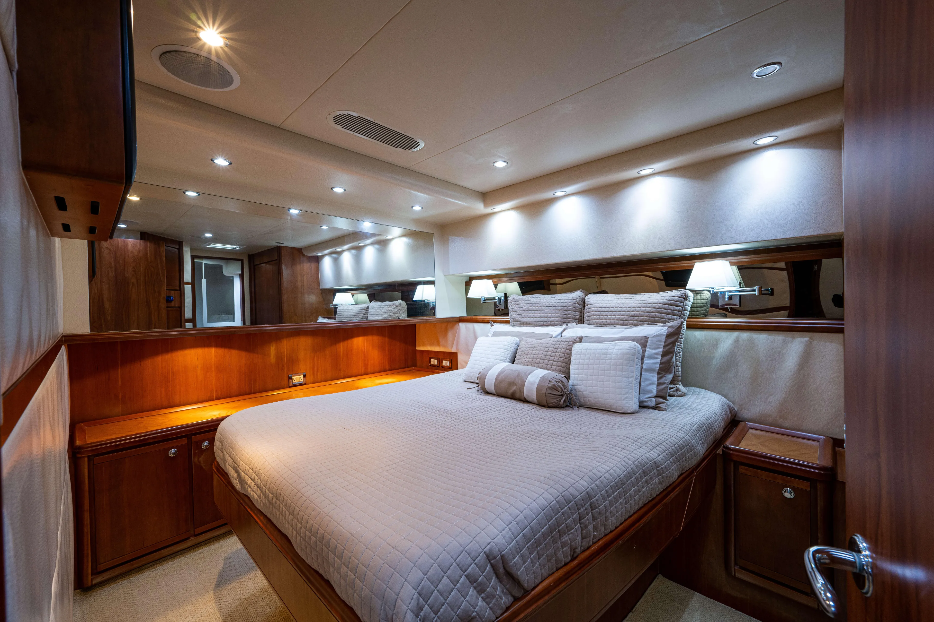 Nine Yacht Photos Pics Luxurious bedroom interior of 2008 Bertram 570 yacht with elegant wood finishes and ambient lighting.