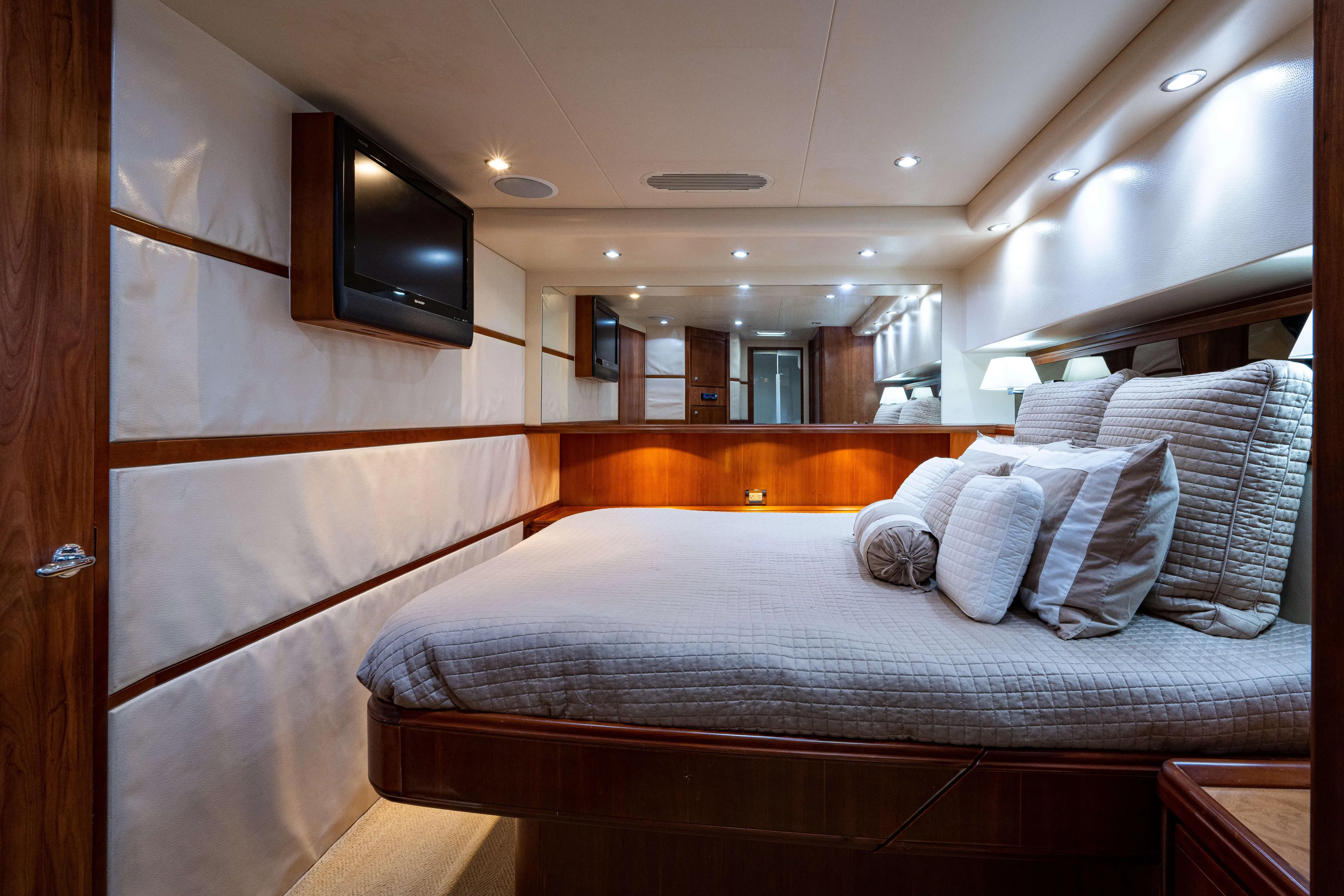 Nine Yacht Photos Pics Luxurious bedroom interior of 2008 Bertram 570 yacht with elegant wood finishes.