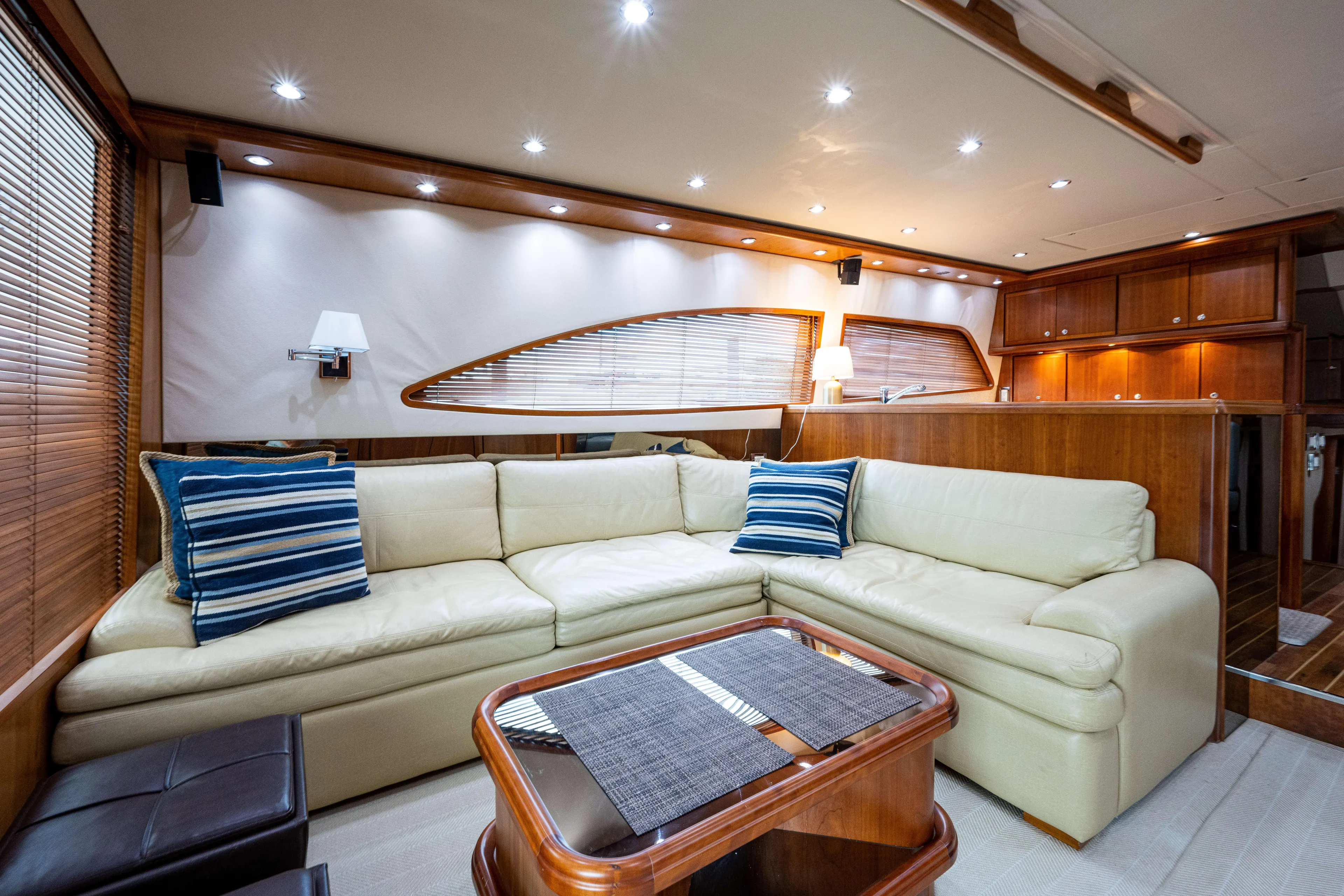 Nine Yacht Photos Pics Luxurious interior of 2008 Bertram 570 yacht with cream sofa and wooden accents.
