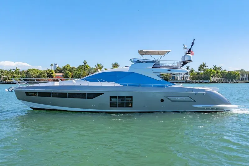 Azimut S7 Yacht Photos Pics 2019 Azimut S7 yacht cruising on a sunny day, surrounded by lush greenery.